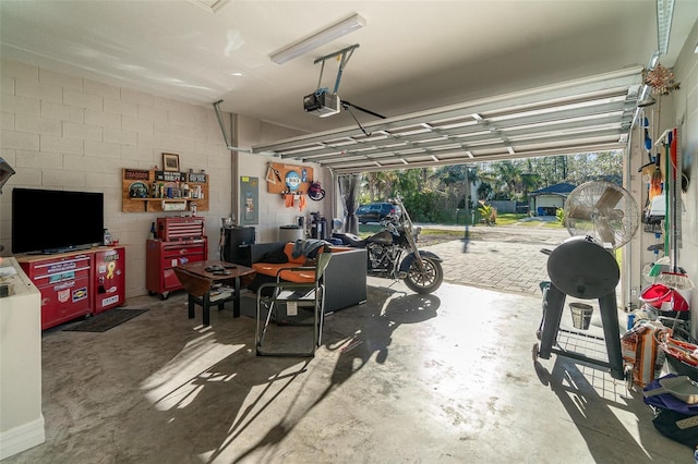 garage with concrete block wall and a garage door opener