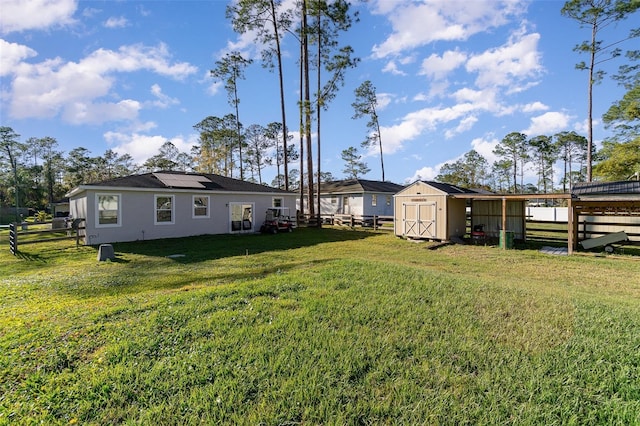 view of yard with an outbuilding, fence, and a shed