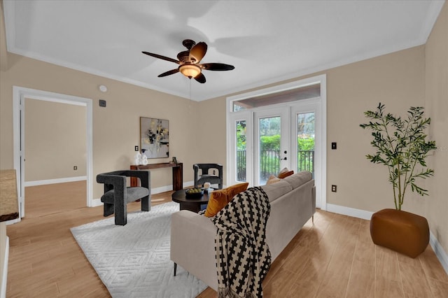 living room with ceiling fan, light wood finished floors, and baseboards