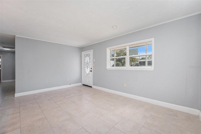 tiled spare room featuring baseboards and ornamental molding