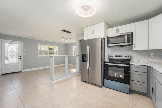 kitchen with tasteful backsplash, stainless steel appliances, white cabinets, light countertops, and light tile patterned floors