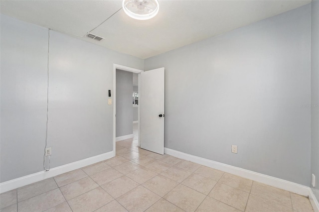 unfurnished room with visible vents, baseboards, and light tile patterned flooring