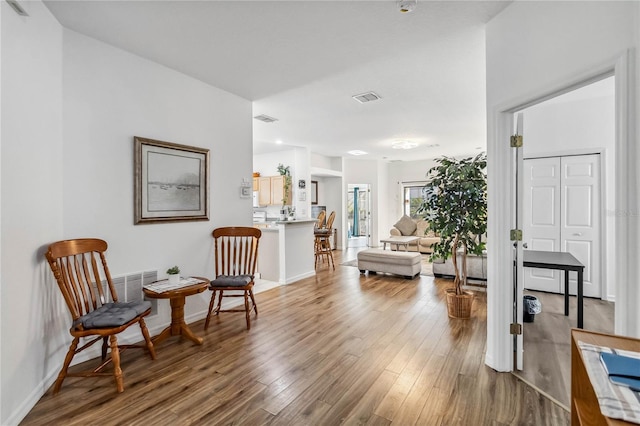 sitting room featuring visible vents, baseboards, and wood finished floors