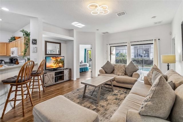 living room featuring visible vents and wood finished floors