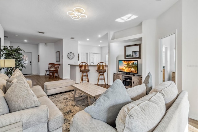 living area featuring recessed lighting, baseboards, and wood finished floors