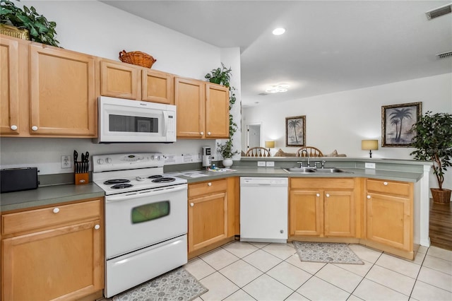 kitchen with visible vents, a sink, white appliances, a peninsula, and light tile patterned floors