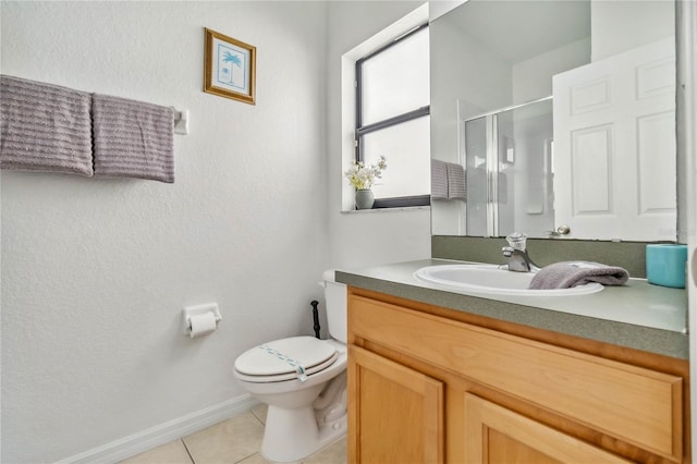 full bathroom with vanity, baseboards, tile patterned flooring, a shower stall, and toilet