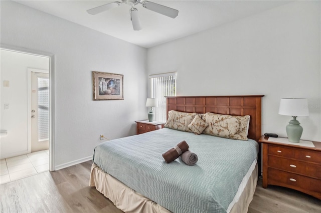 bedroom featuring multiple windows, light wood-style floors, baseboards, and ceiling fan