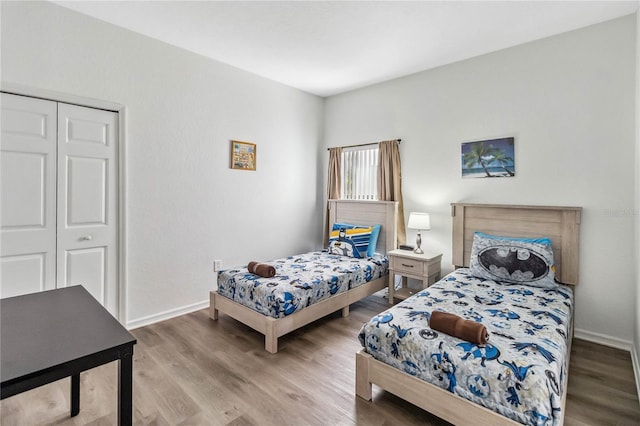 bedroom featuring a closet, baseboards, and wood finished floors