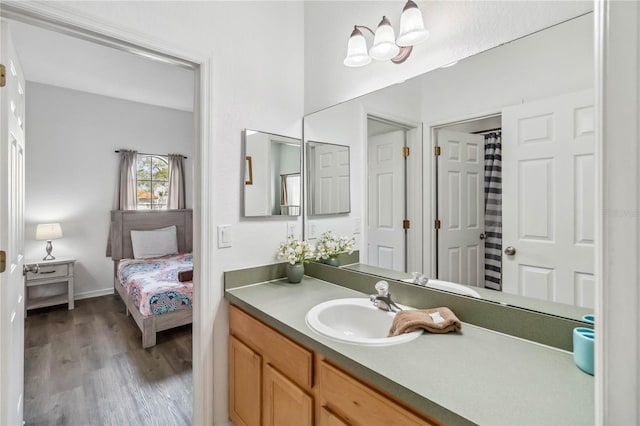 full bathroom featuring vanity, a shower with shower curtain, baseboards, and wood finished floors