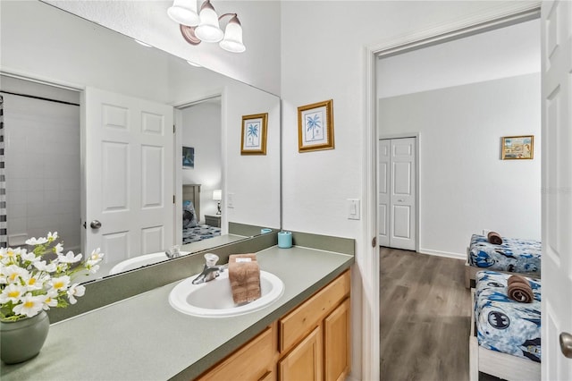 full bath featuring vanity, ensuite bath, and wood finished floors