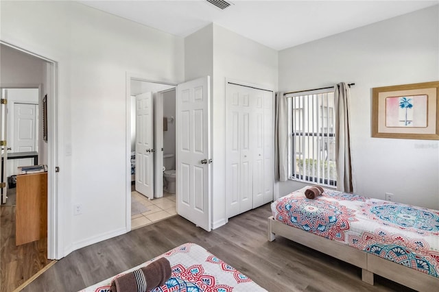 bedroom with wood finished floors and a closet