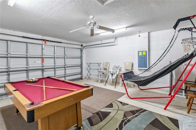 garage with electric panel, ceiling fan, and concrete block wall