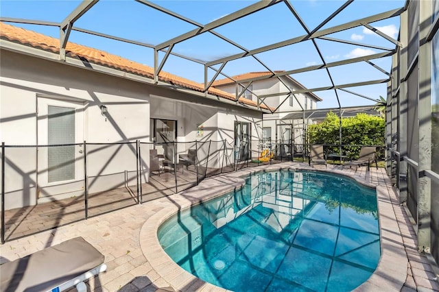 outdoor pool with a lanai and a patio area