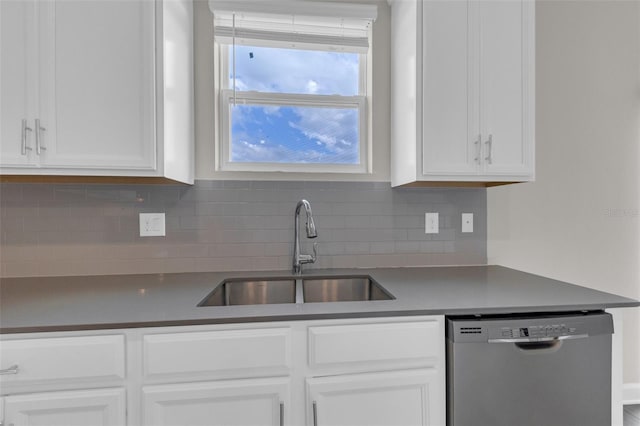 kitchen featuring stainless steel dishwasher, decorative backsplash, white cabinets, and a sink