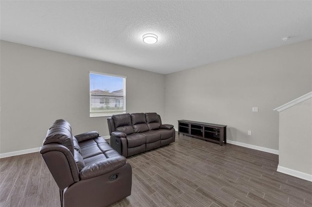 living area with wood finished floors, baseboards, and a textured ceiling