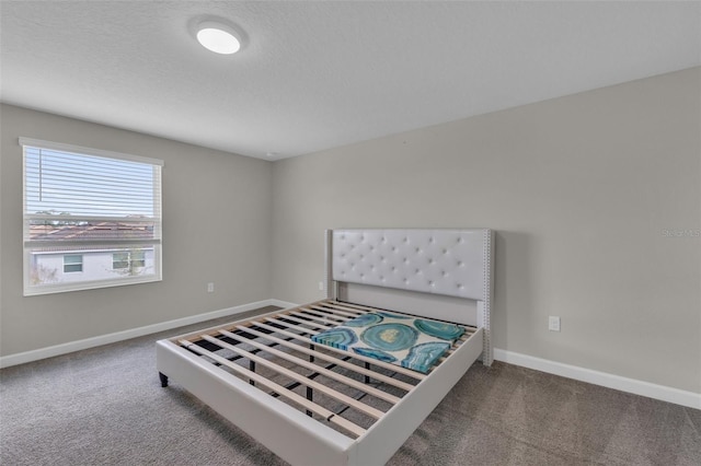 carpeted bedroom featuring a textured ceiling and baseboards