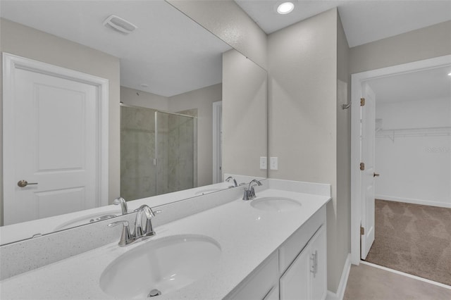 bathroom with a sink, double vanity, and a shower stall