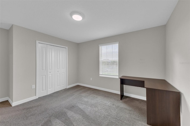 unfurnished bedroom featuring a closet, carpet flooring, and baseboards