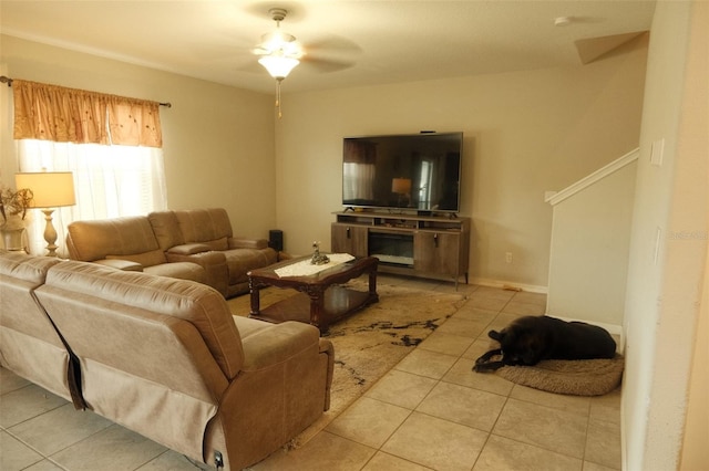 tiled living room featuring ceiling fan and baseboards