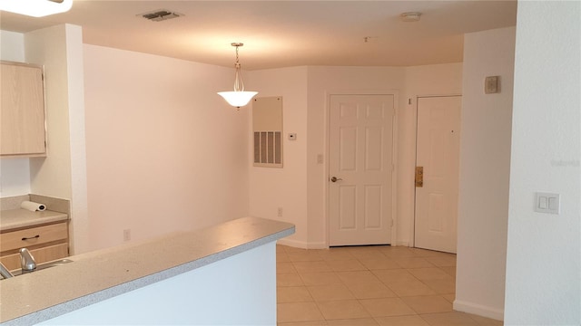 kitchen featuring light tile patterned floors, visible vents, light countertops, and decorative light fixtures