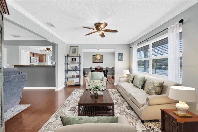 living room with baseboards, visible vents, a ceiling fan, wood finished floors, and a textured ceiling