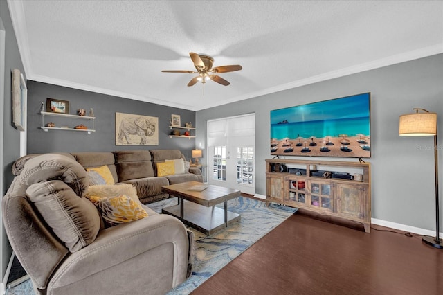 living room with baseboards, a ceiling fan, ornamental molding, wood finished floors, and a textured ceiling