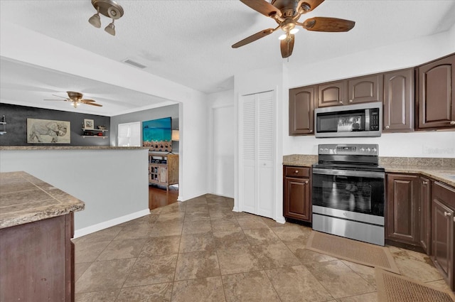 kitchen with a textured ceiling, visible vents, stainless steel appliances, and dark brown cabinets