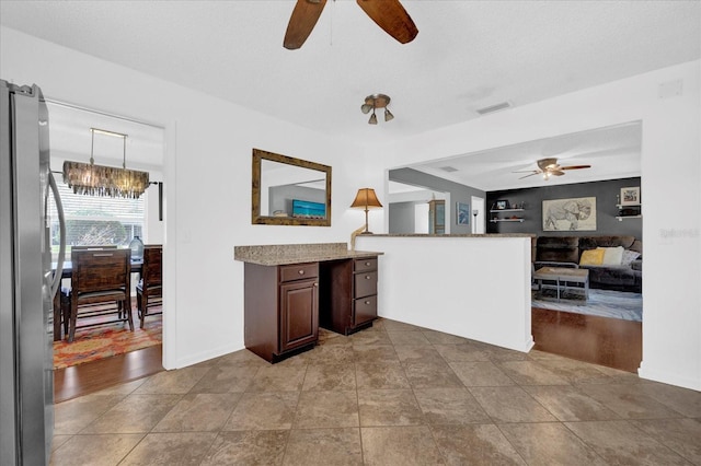 kitchen featuring light tile patterned floors, visible vents, a ceiling fan, freestanding refrigerator, and open floor plan