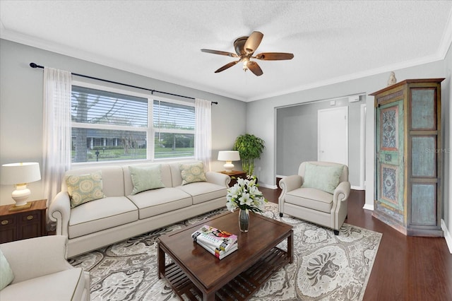 living room featuring crown molding, a ceiling fan, a textured ceiling, wood finished floors, and baseboards