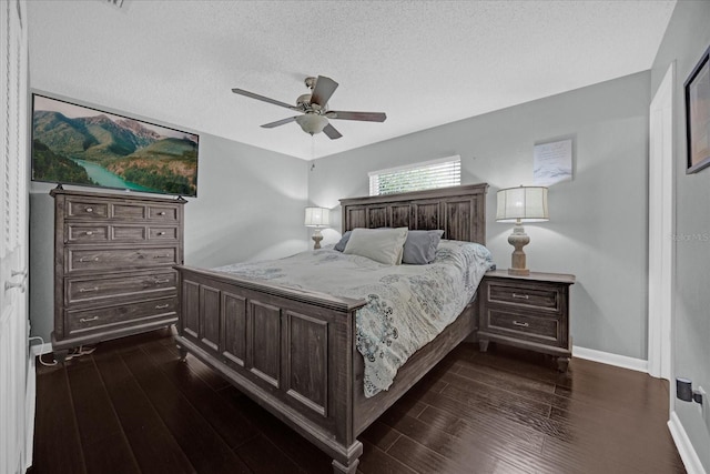 bedroom featuring a textured ceiling, dark wood-style flooring, a ceiling fan, and baseboards