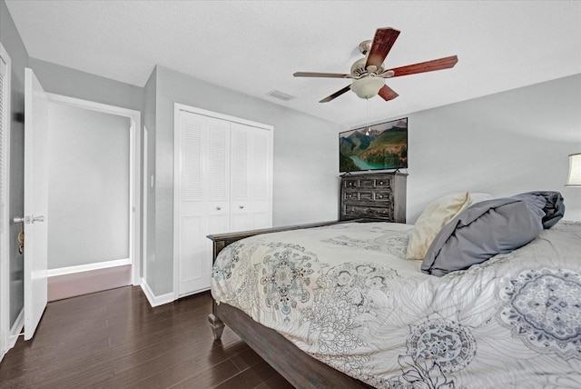 bedroom featuring a closet, visible vents, ceiling fan, wood finished floors, and baseboards