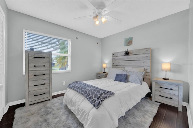 bedroom featuring ceiling fan, baseboards, and dark wood-type flooring