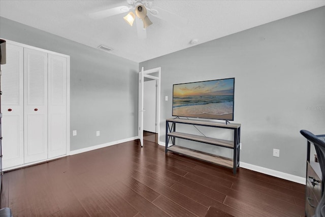 bedroom with a closet, wood finished floors, visible vents, and baseboards