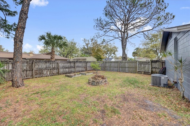 view of yard with a fenced backyard and central AC unit