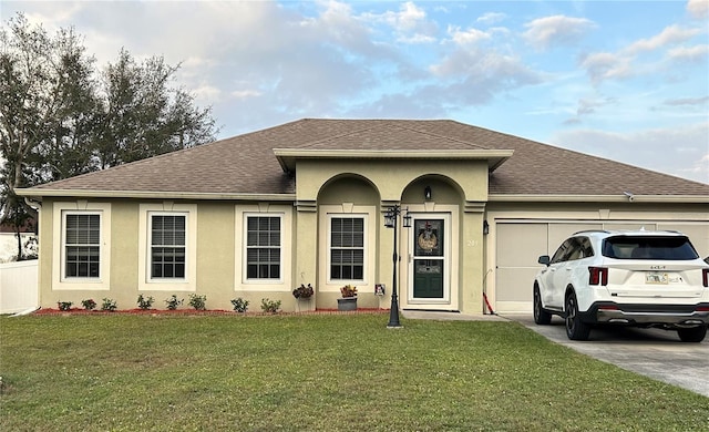 ranch-style home with an attached garage, concrete driveway, roof with shingles, stucco siding, and a front yard