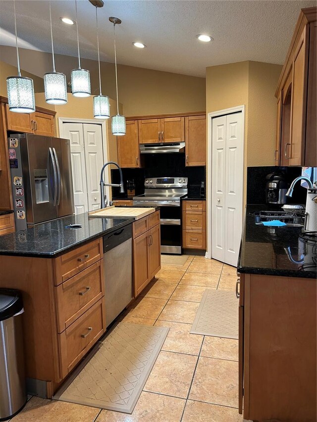 kitchen featuring appliances with stainless steel finishes, a sink, under cabinet range hood, and an island with sink