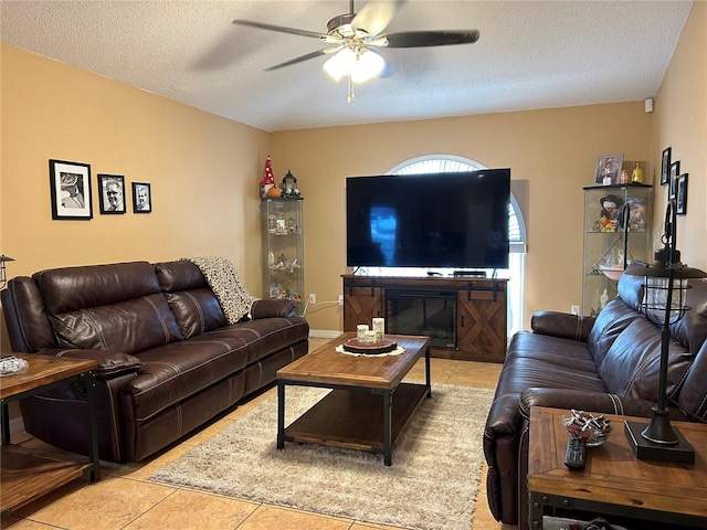 living room with a textured ceiling, tile patterned flooring, and a ceiling fan