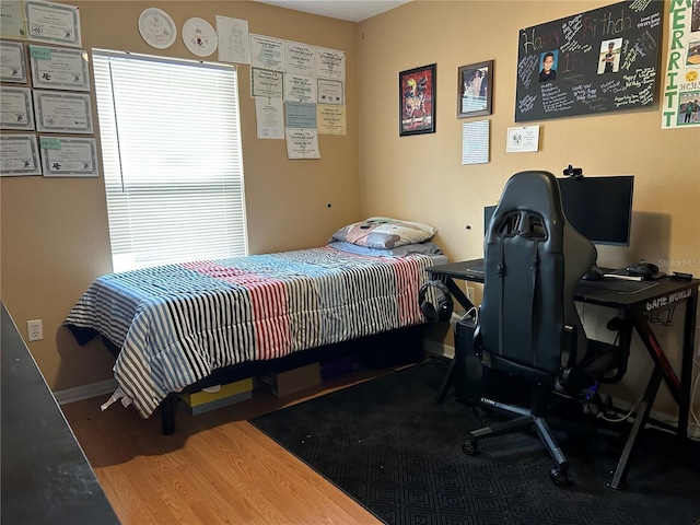 bedroom with wood finished floors and baseboards