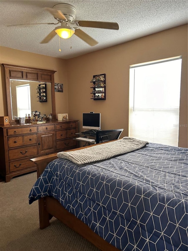 bedroom with carpet floors, ceiling fan, multiple windows, and a textured ceiling