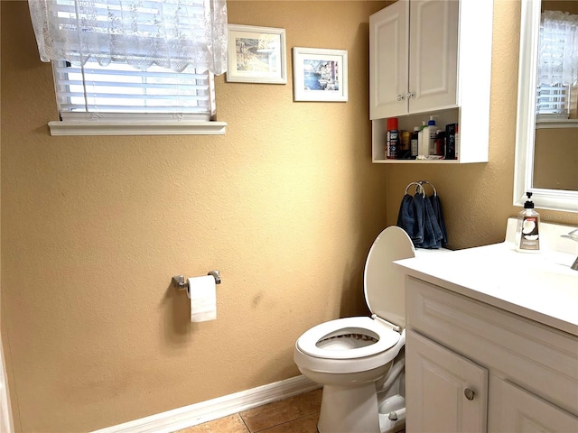 bathroom featuring a textured wall, toilet, vanity, tile patterned flooring, and baseboards