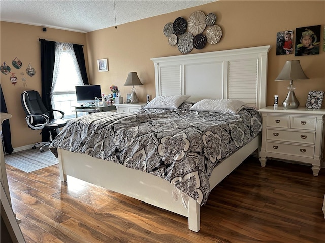 bedroom with dark wood-style floors and a textured ceiling