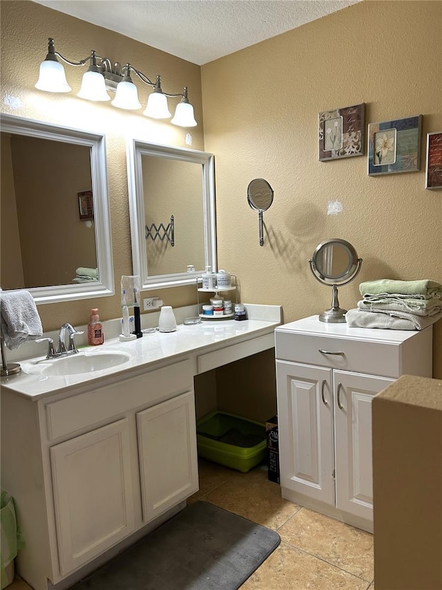 bathroom featuring vanity, a textured ceiling, and a textured wall