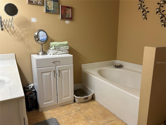 bathroom with a garden tub, vanity, and tile patterned floors