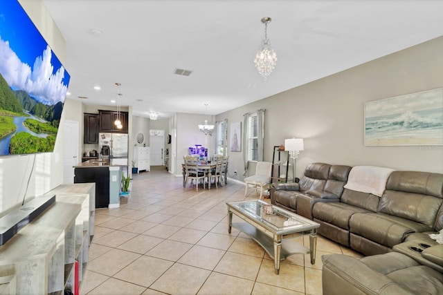 living area with light tile patterned floors, baseboards, visible vents, a notable chandelier, and recessed lighting