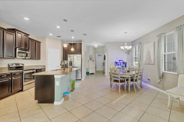 kitchen with dark brown cabinetry, appliances with stainless steel finishes, a sink, and light tile patterned flooring