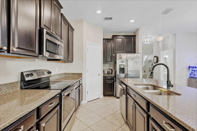 kitchen featuring visible vents, appliances with stainless steel finishes, dark brown cabinets, and a sink