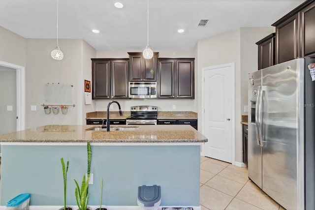 kitchen with stainless steel appliances, visible vents, a sink, and light stone counters