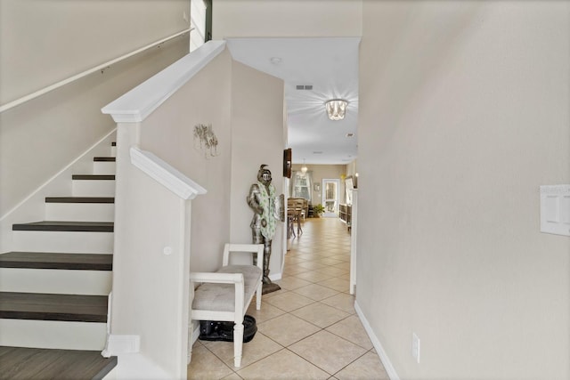 staircase with baseboards, visible vents, and tile patterned floors