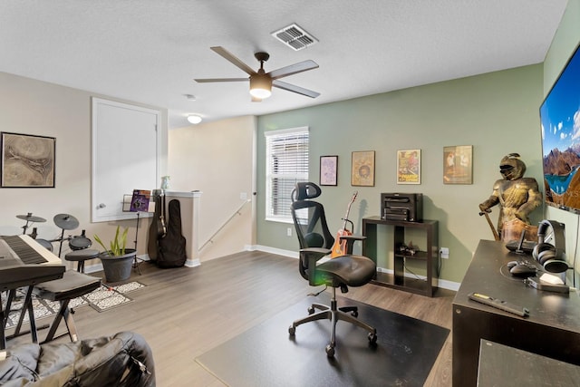 office space with baseboards, visible vents, and wood finished floors